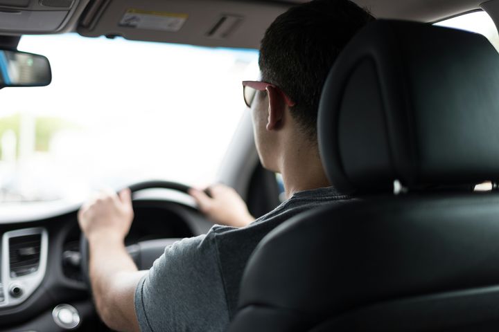 Learner driving on the road seen from the back seat