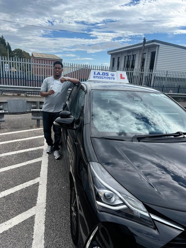 Driving school student holding their driving test pass certificate